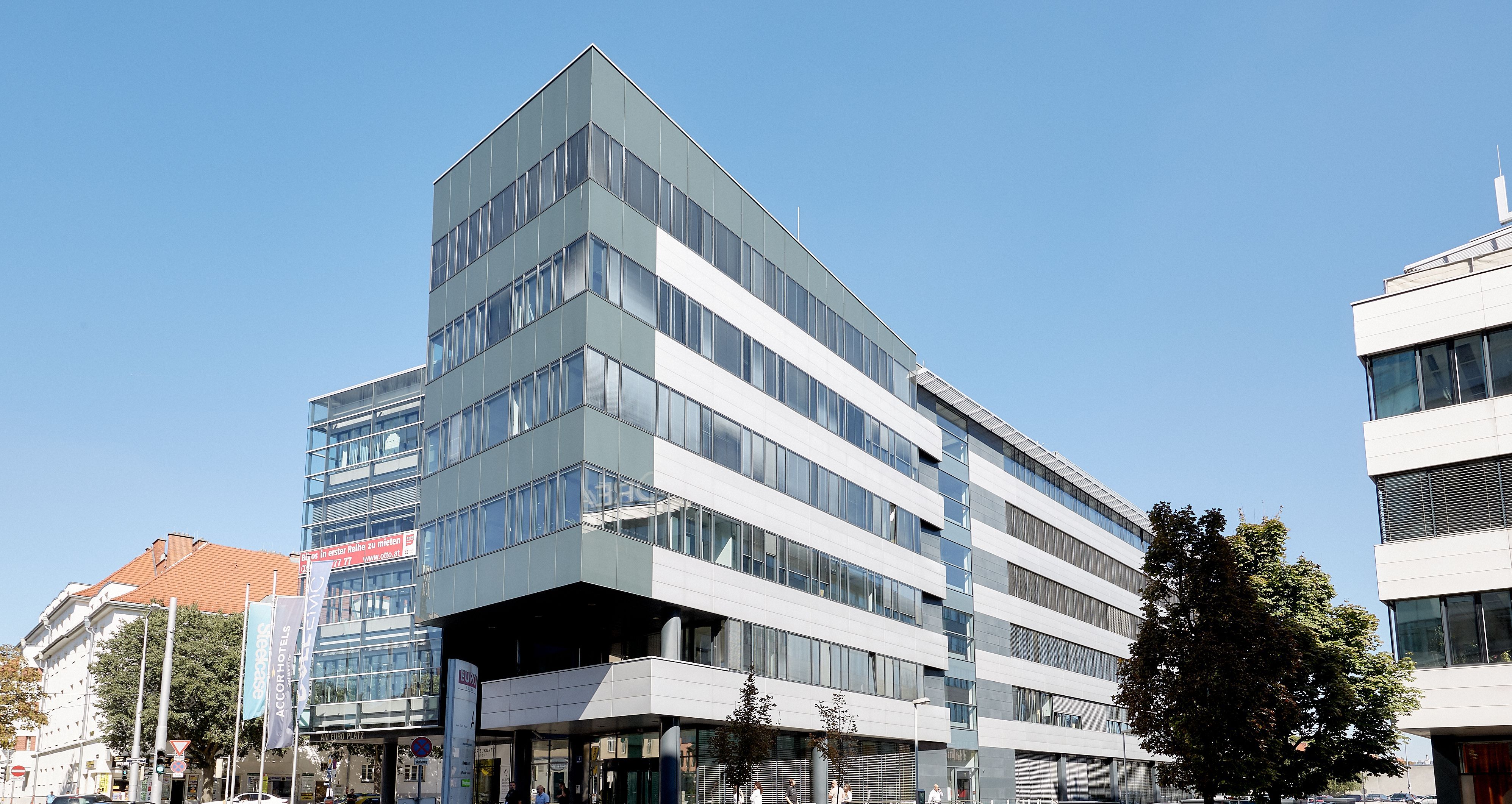 Foto: modernes Bürogebäude mit sechs Geschoßen und moderner Alu-Glasfassade in urbaner Umgebung